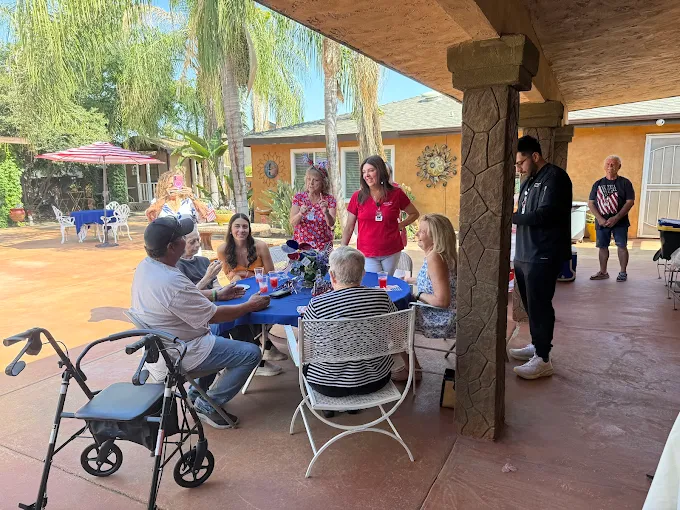 Glory Days Visalia staff and residents enjoying outdoor social activity and family interaction under a covered patio for assisted care living and memory support.